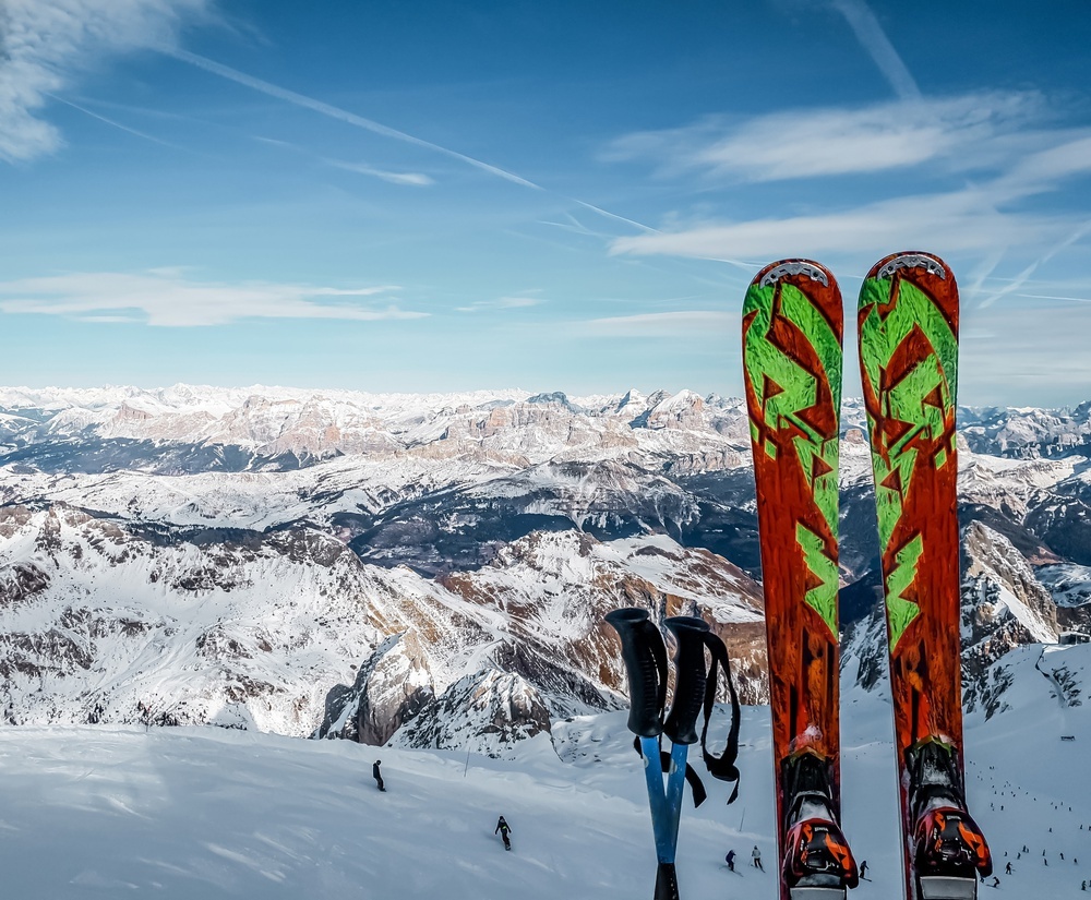 El hombre muestra botas de esquí o snowboard blancas y negras en la tienda  de deportes. estilo de vida extremo de temporada de invierno, ocio activo,  cliente masculino con equipo de protección