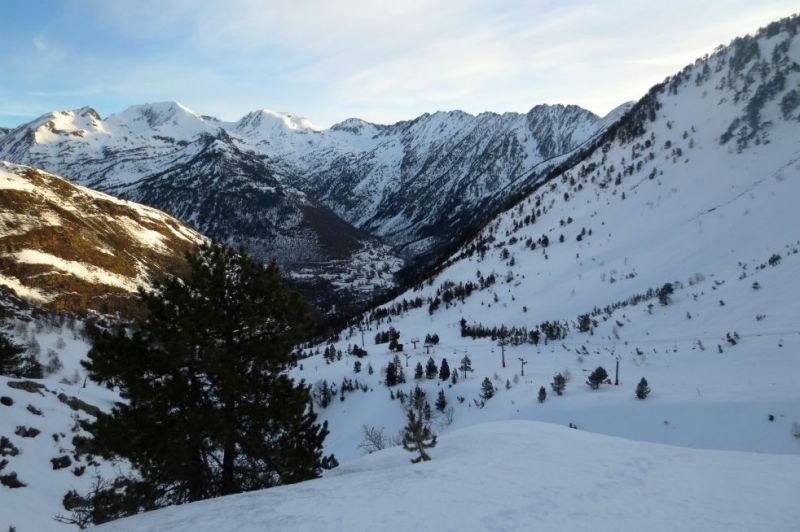 una vall coberta de neige avec des montagnes en arrière-plan