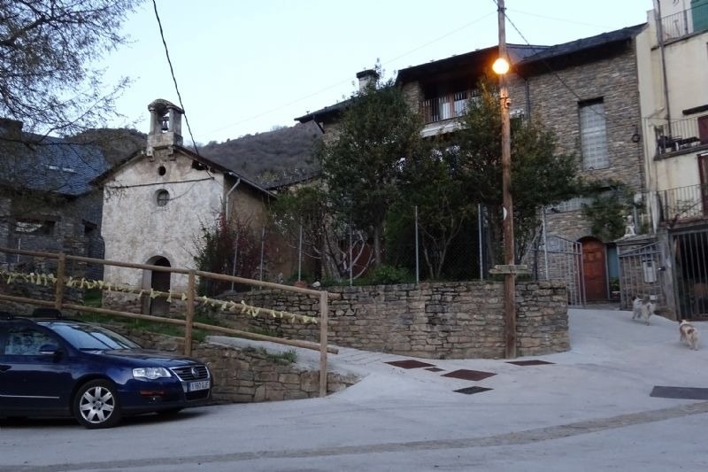 a blue car is parked in front of a stone building