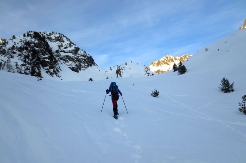 una persona amb una mochila azul camina por la nieve