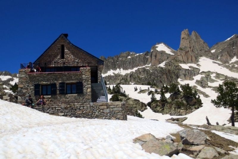 un edificio de piedra en la cima de una montaña cubierta de nieve