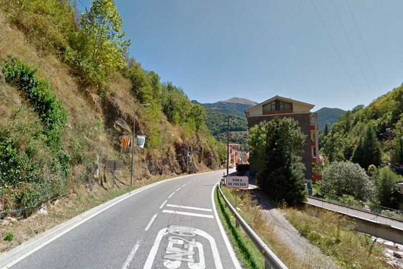 une route avec un panneau à l' entrée de la ville