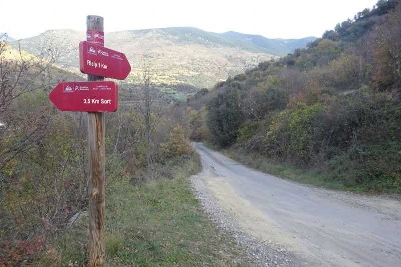 un cartell vermell apunta a l' esquerra i a l' esquerra de la carretera