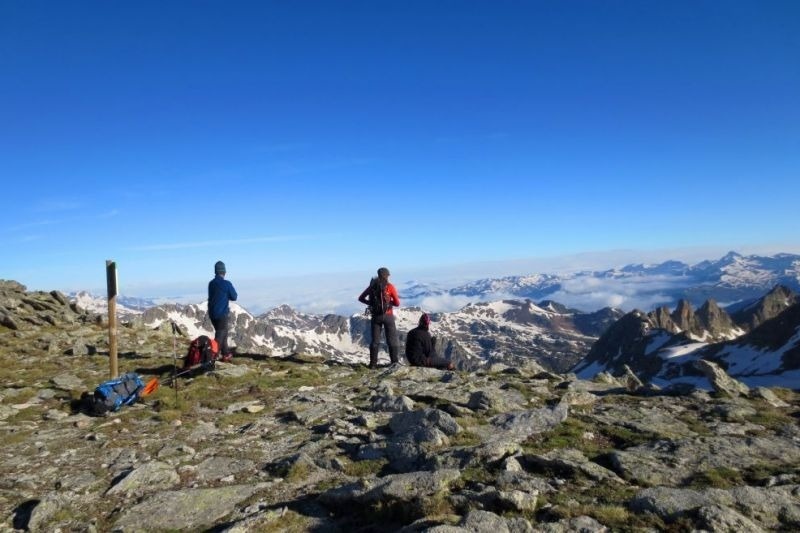 un grupo de personas están de pie en la cima de una montaña