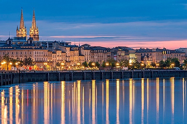 a city is reflected in a body of water at night