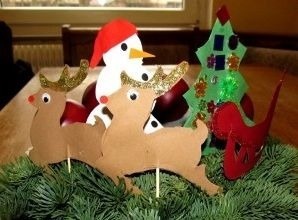 un muñeco de nieve , renos y un árbol de navidad están sobre una mesa .