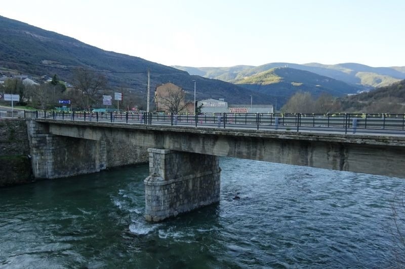 un puente sobre un río con un edificio en el fondo que dice victoria