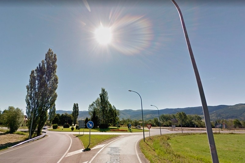 une route avec un panneau bleu indiquant qu'il y a un virage à droite