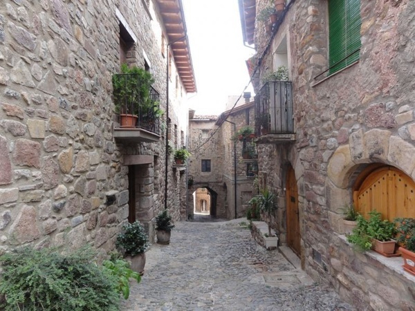 un edificio de piedra con balcones y plantas en macetas