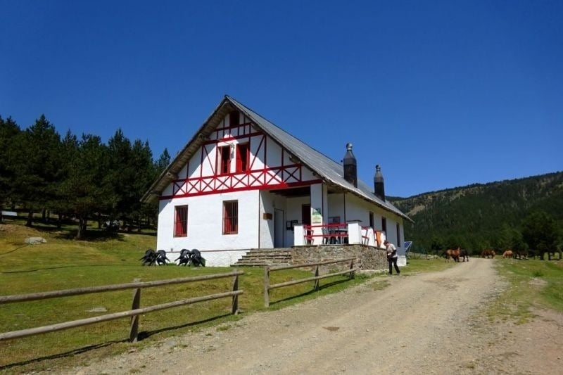 una casa blanca i vermella a la ladera de la montagna