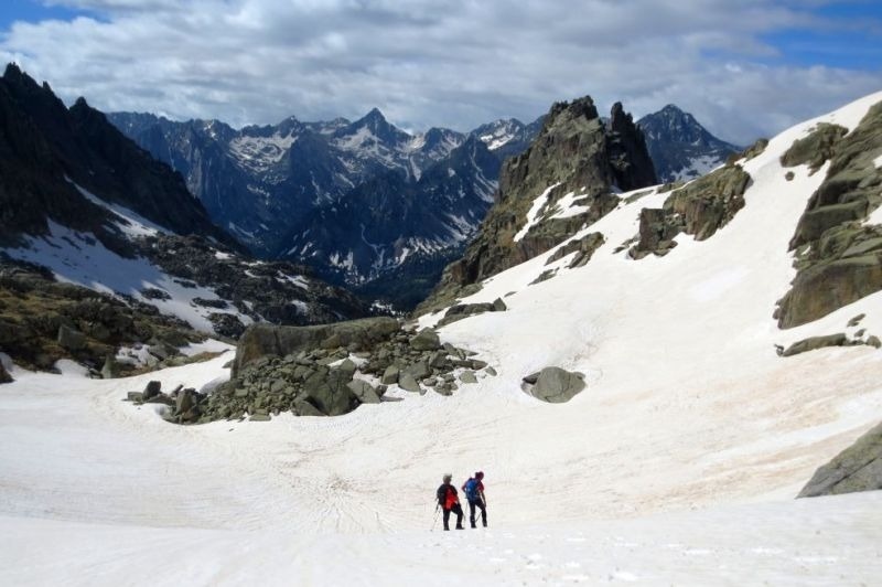 dos hombres parados en la nieve con montañas en el fondo