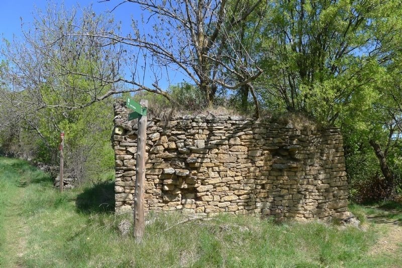 a stone wall with a green sign that says ' a ' on it