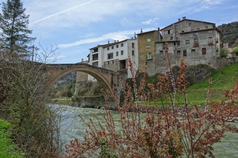 un puente sobre un río con edificios en el fondo