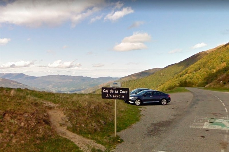 une voiture est garée à côté d' un panneau indiquant le col de la core