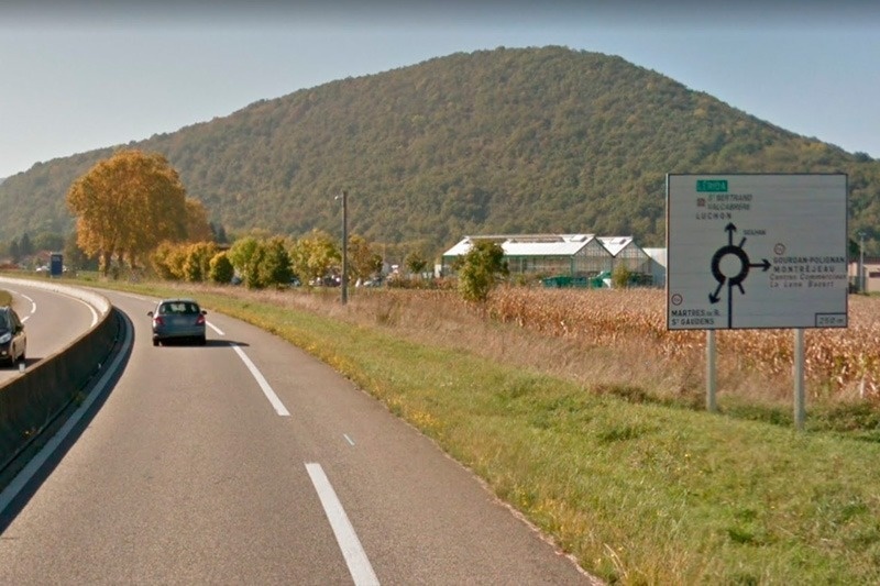 a sign on the side of a road shows a roundabout