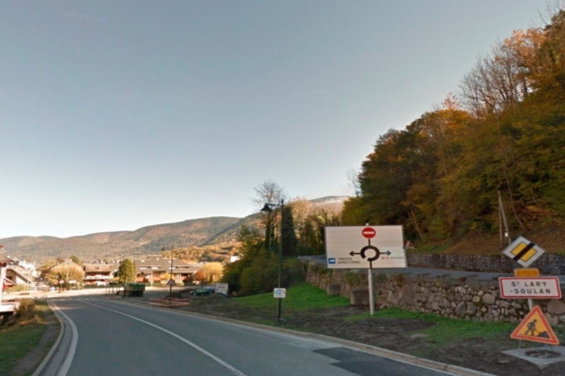 une route avec un panneau indiquant qu'il y a un rond-point