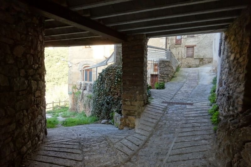 a narrow stone alleyway leading to a building