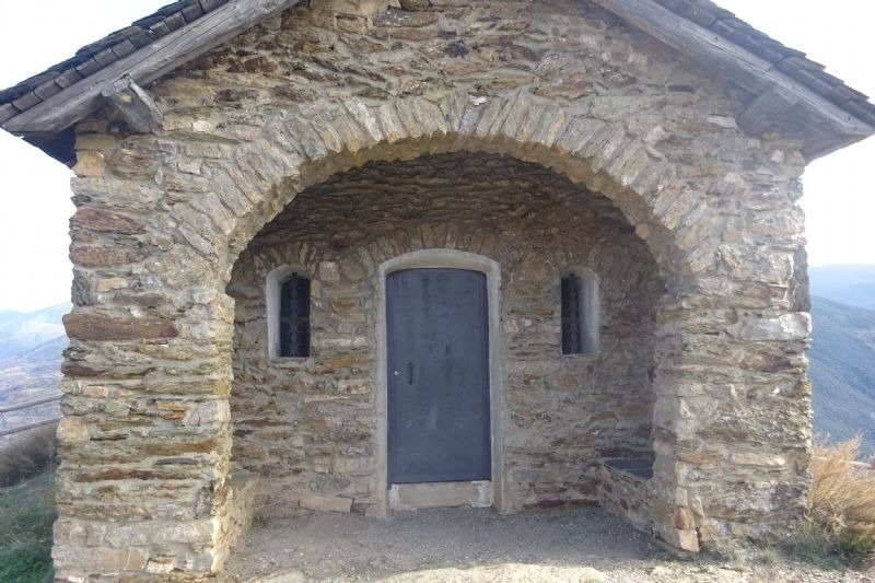 un edifici de pedra amb una porta i dues finestres
