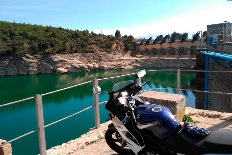 una motocicleta suzuki está estacionada junto a un lago