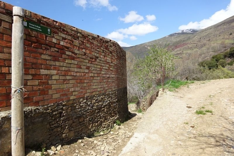 a brick wall with a sign on it that says camino de la montaña