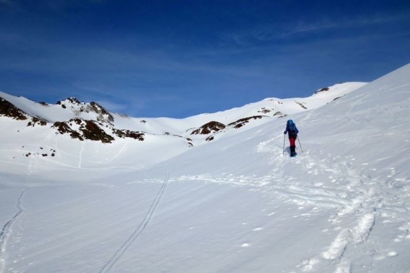 una persona camina a través d' un paisatge de montagnes cobertes de neige