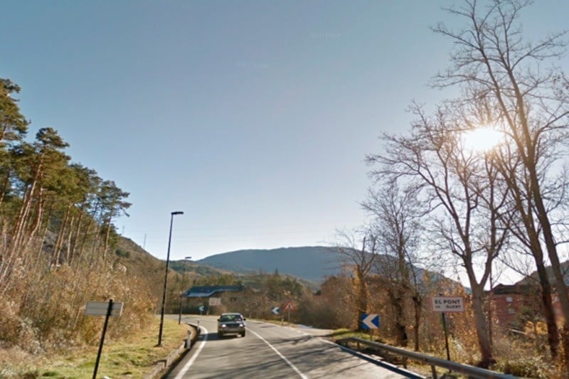 une voiture roule sur une route à côté d' un panneau indiquant el pont