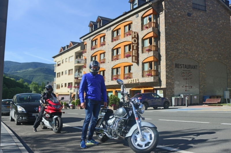 un homme se tient à côté d' une moto à l' extérieur d' un restaurant