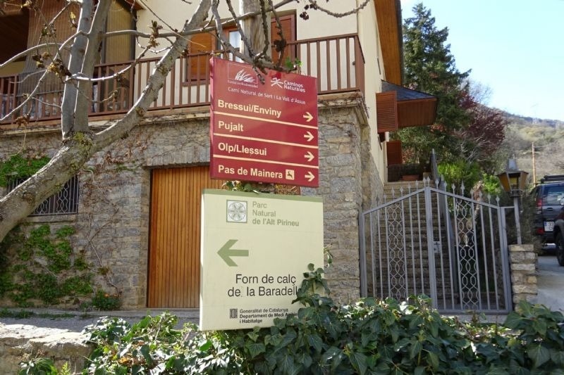 a sign points the way to a park called forn de calc de la baradel