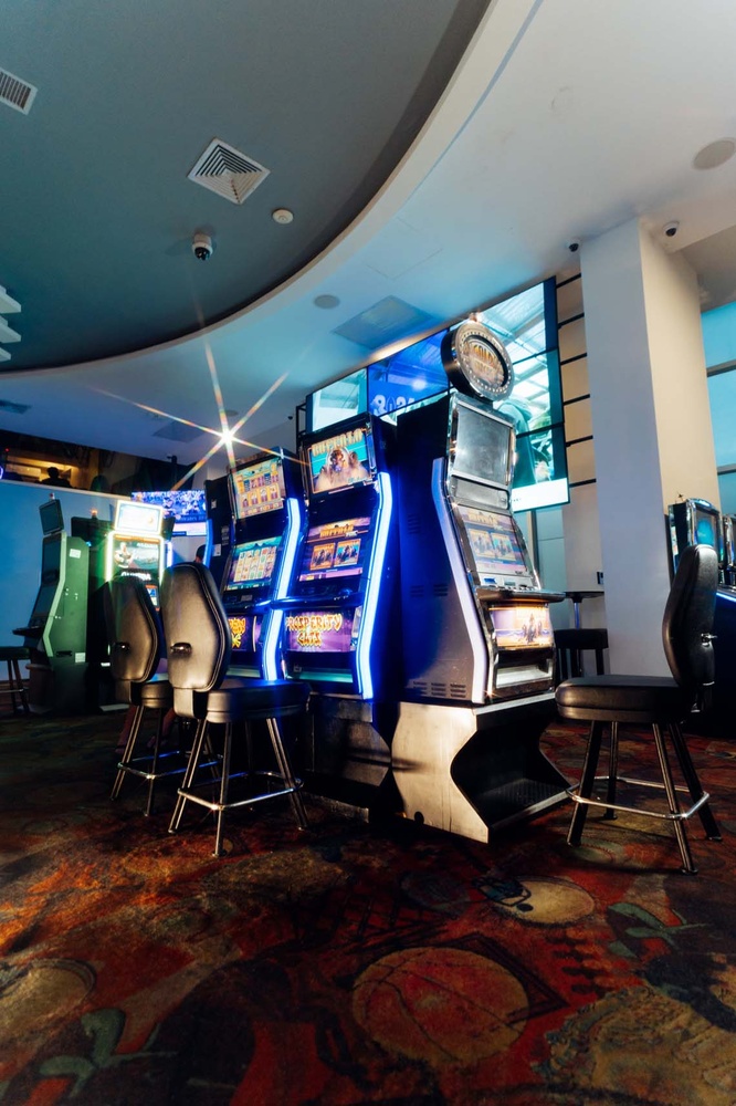 LHVC Resorts: Bright slot machines and bar stools in casino area.