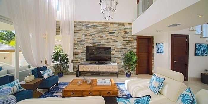 a living room with a couch , chairs , table and television .