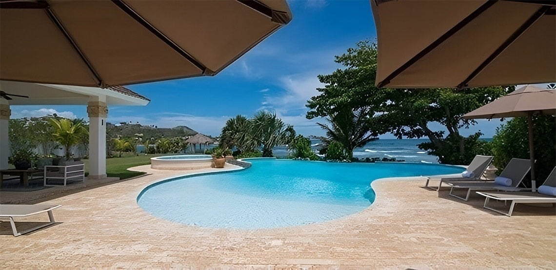 a large swimming pool is surrounded by chairs and umbrellas