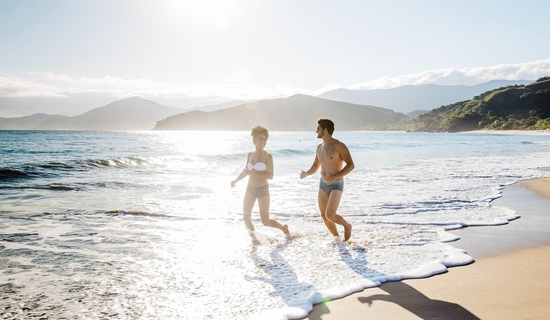 un hombre y una mujer están corriendo en la playa