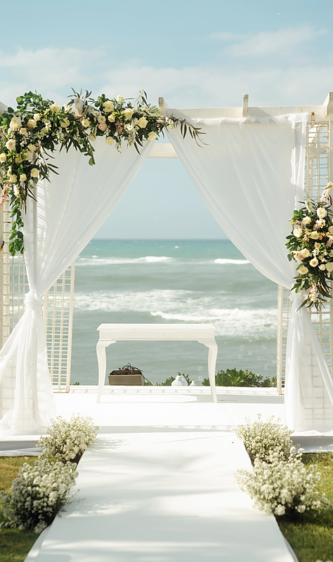 Beachfront wedding ceremony with floral arch