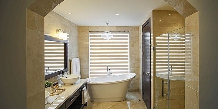 a bathroom with a tub , sink , mirror and shower .