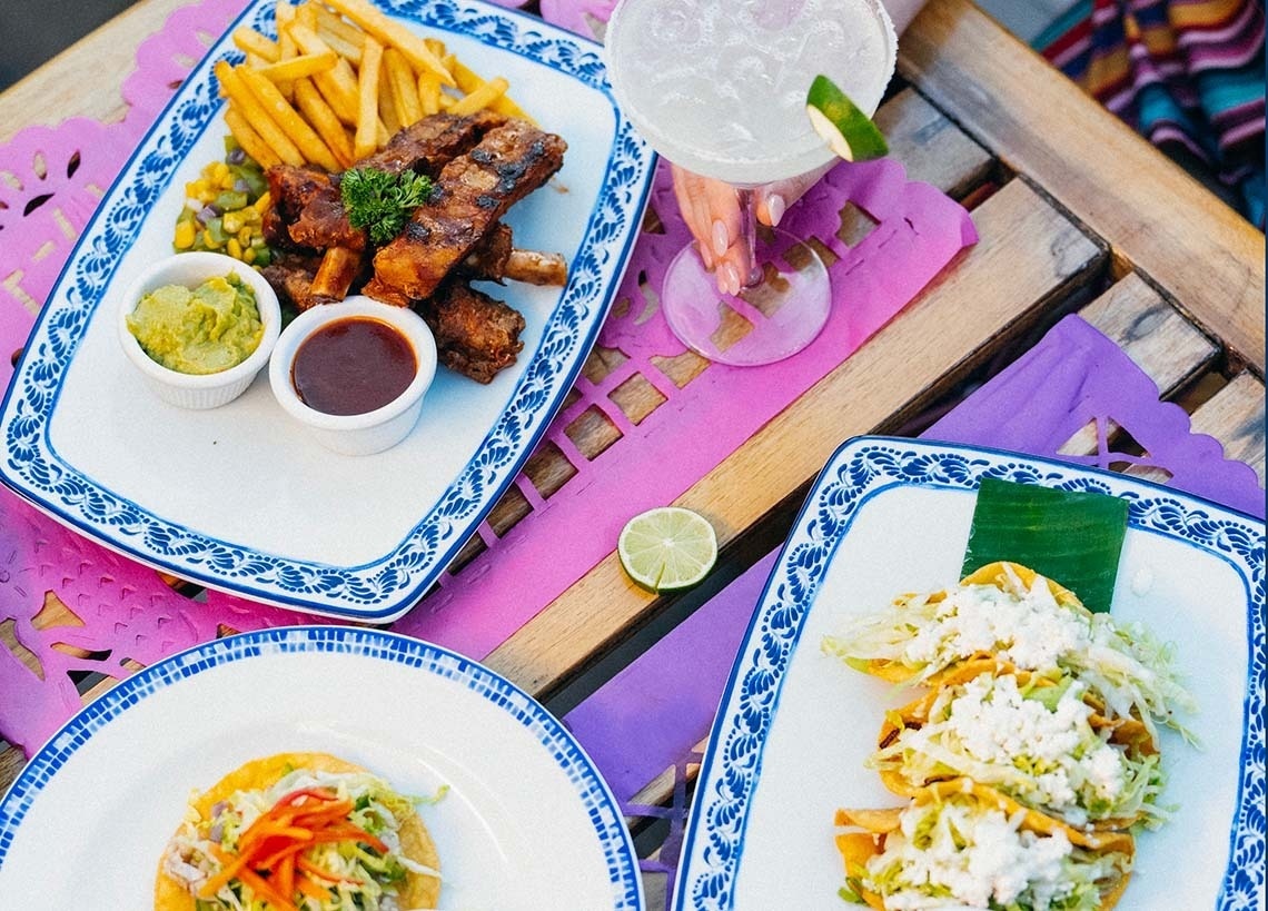 una mesa con un plato y cubiertos y un menú de comida mexicana