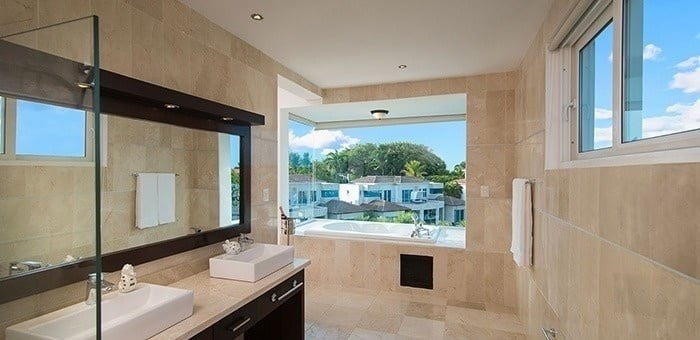 un baño con dos lavabos , una bañera y una ventana .