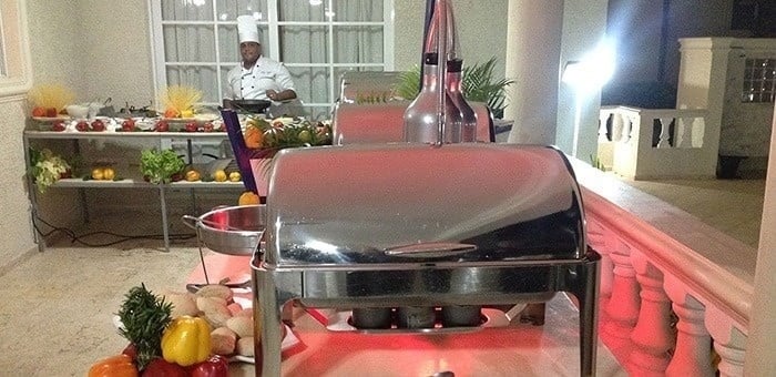 un chef está parado frente a un buffet lleno de comida .