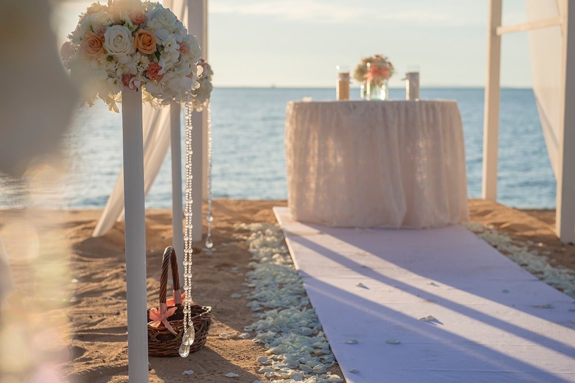 a table with flowers on it sits on the beach