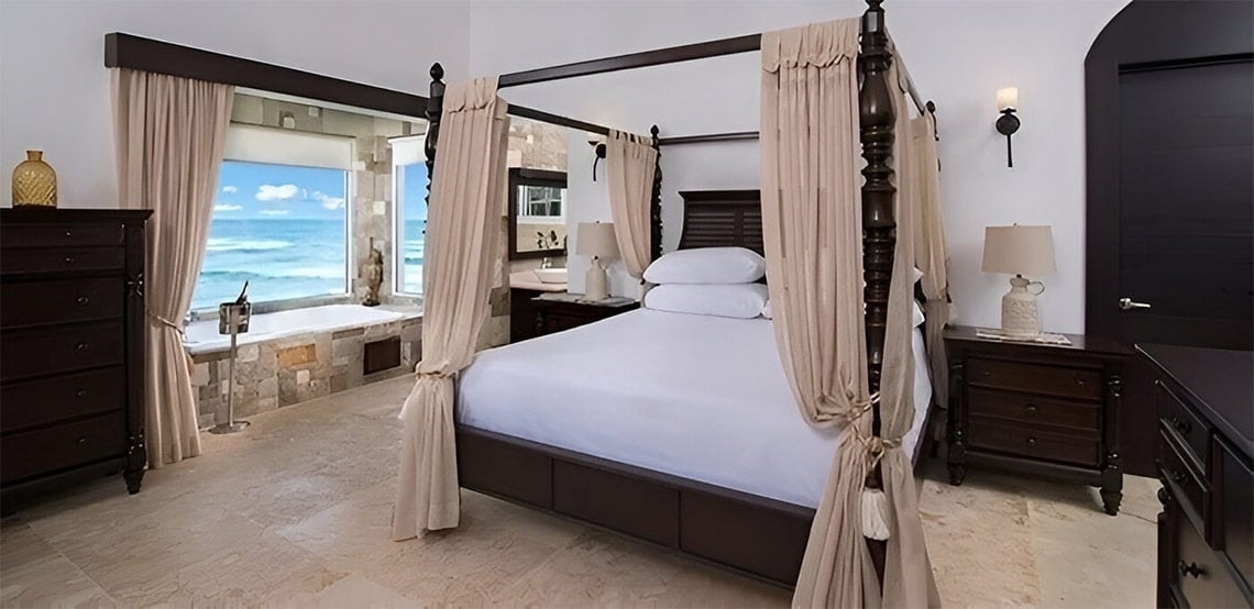 a bedroom with a four poster bed and a bathtub