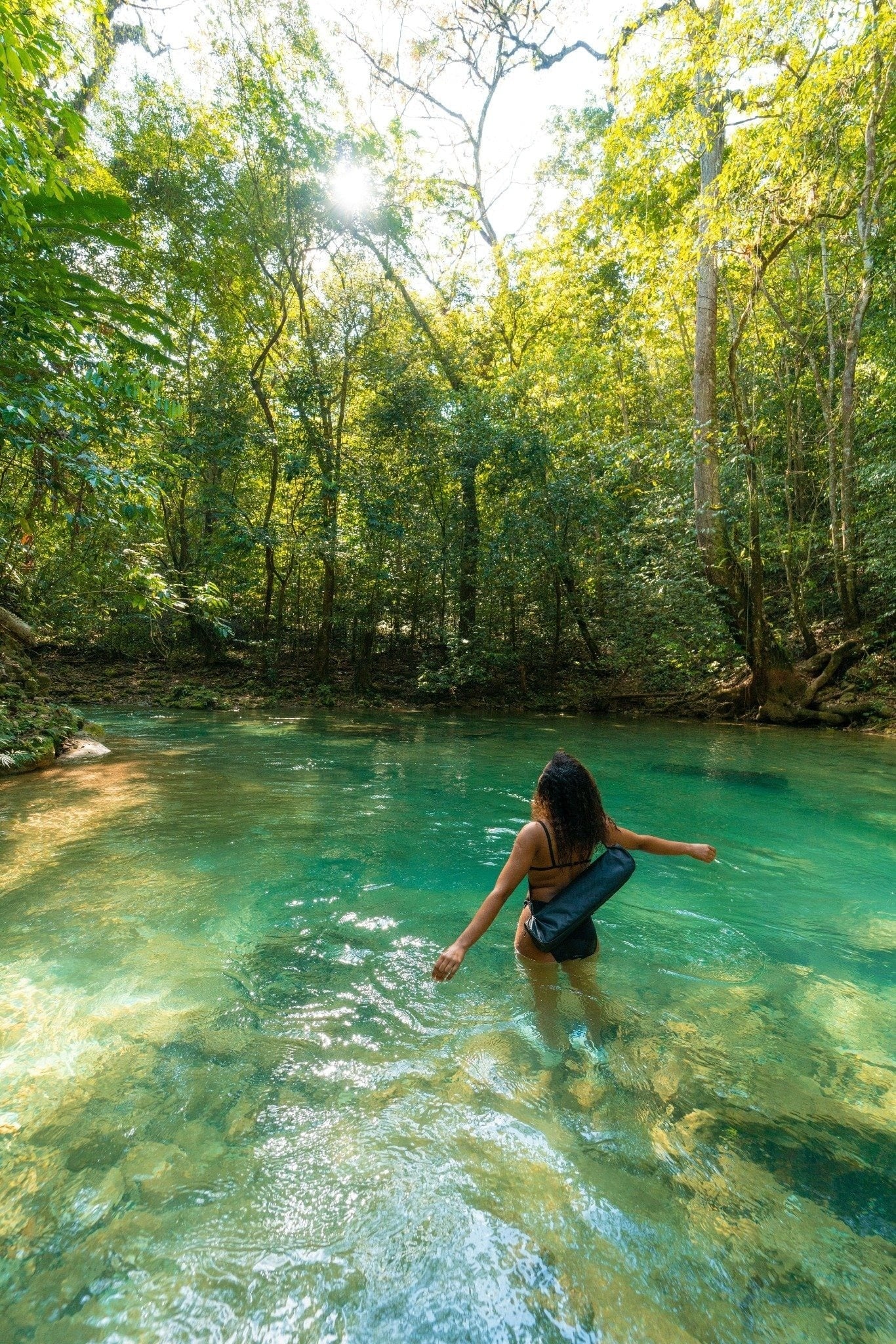 two women in bathing suits are hugging and laughing on the beach
