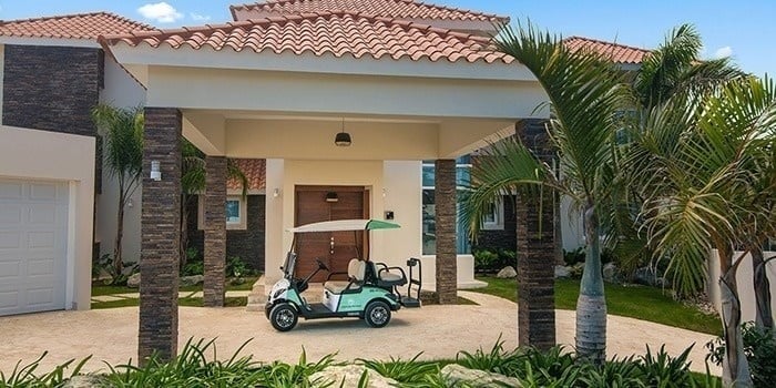 a golf cart is parked in front of a large house .