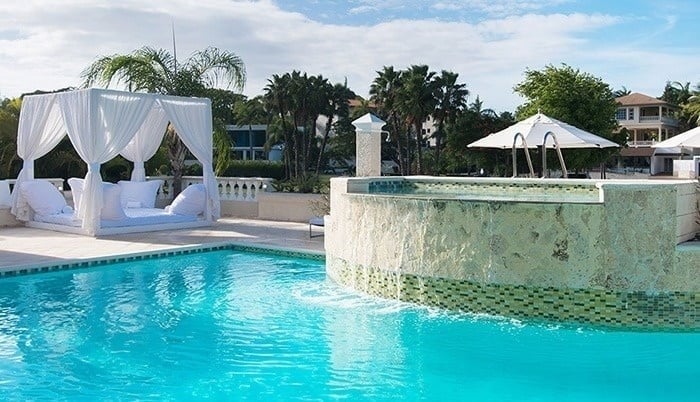 una piscina con una cama con dosel y un jacuzzi