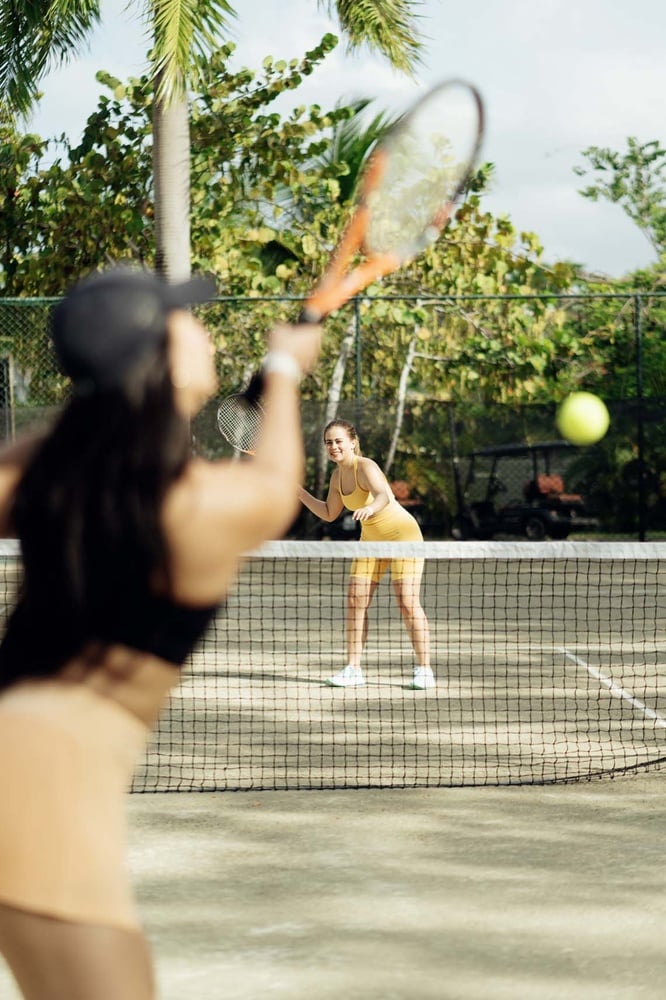 Two women playing tennis at LHVC Resorts: Corpo, outdoor court