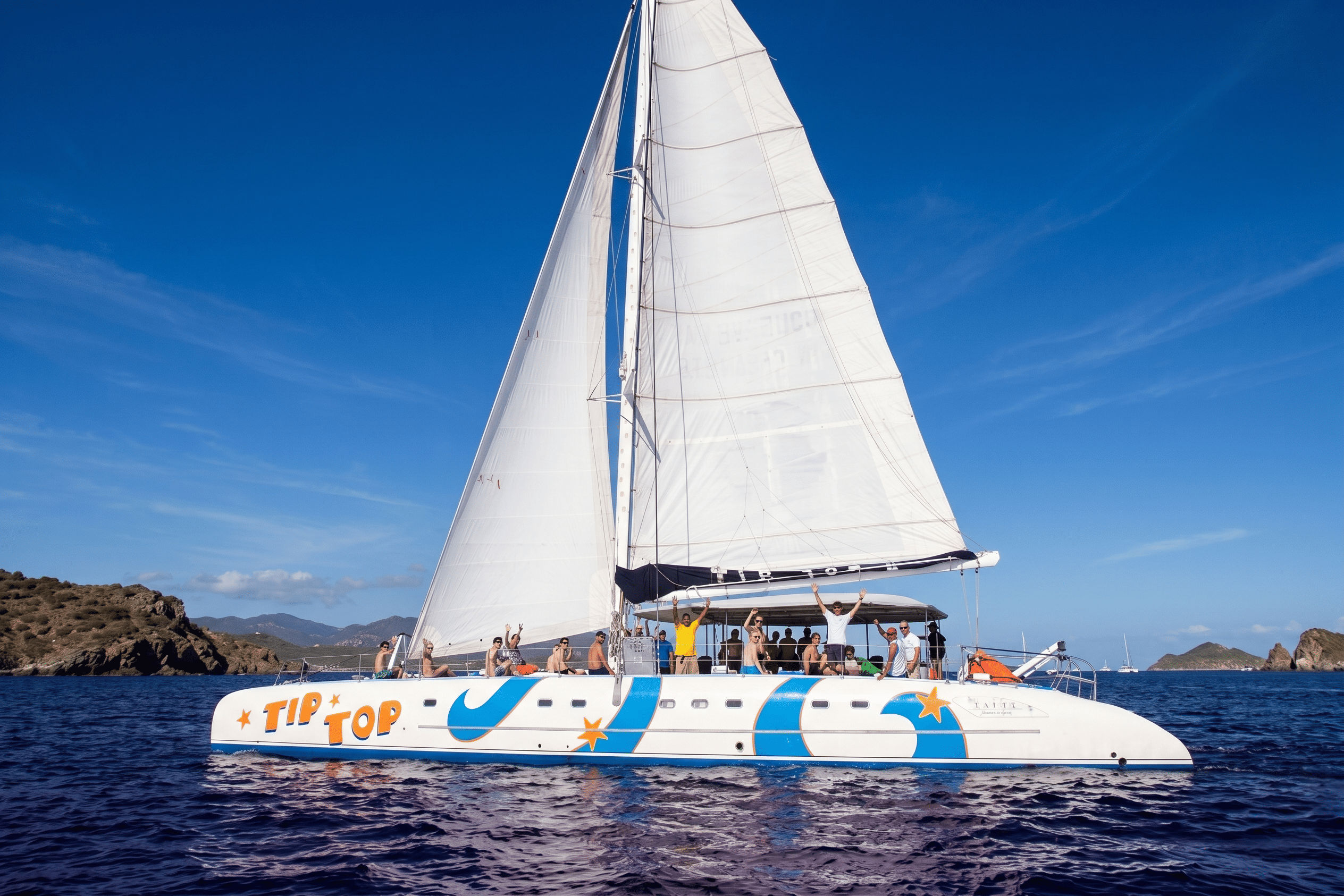 a woman in a bikini is standing on a sailboat in the ocean