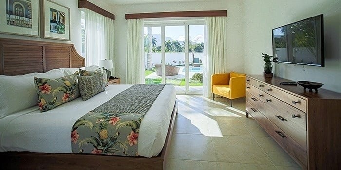 a bedroom with a king size bed , dresser , chair and television .