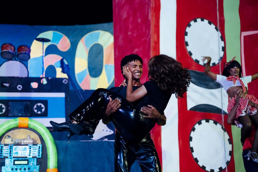 LHVC Resorts: Lively performance. Couple dances with 60s flair against a retro backdrop.