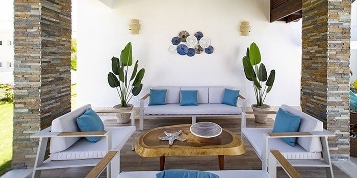 a living room with a couch , chairs , and a wooden table .