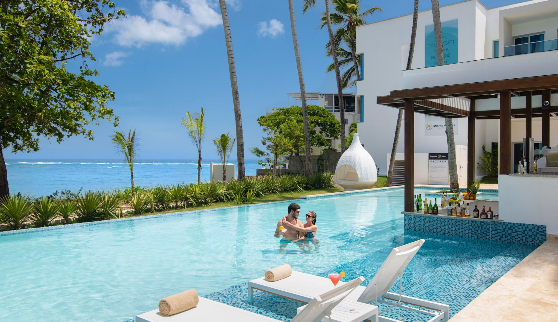 a man and woman are sitting in a swimming pool at a resort
