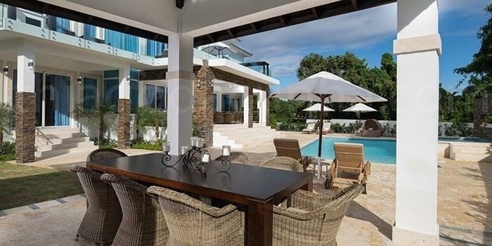 a table and chairs are sitting on a patio next to a swimming pool .