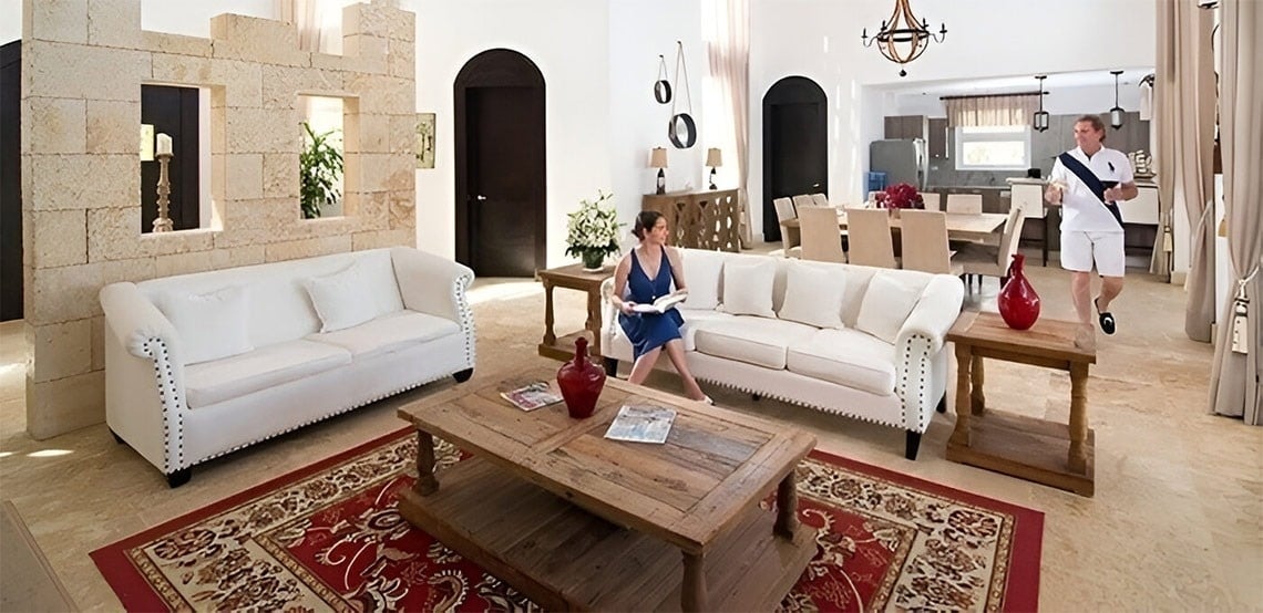 a woman sits on a white couch in a living room